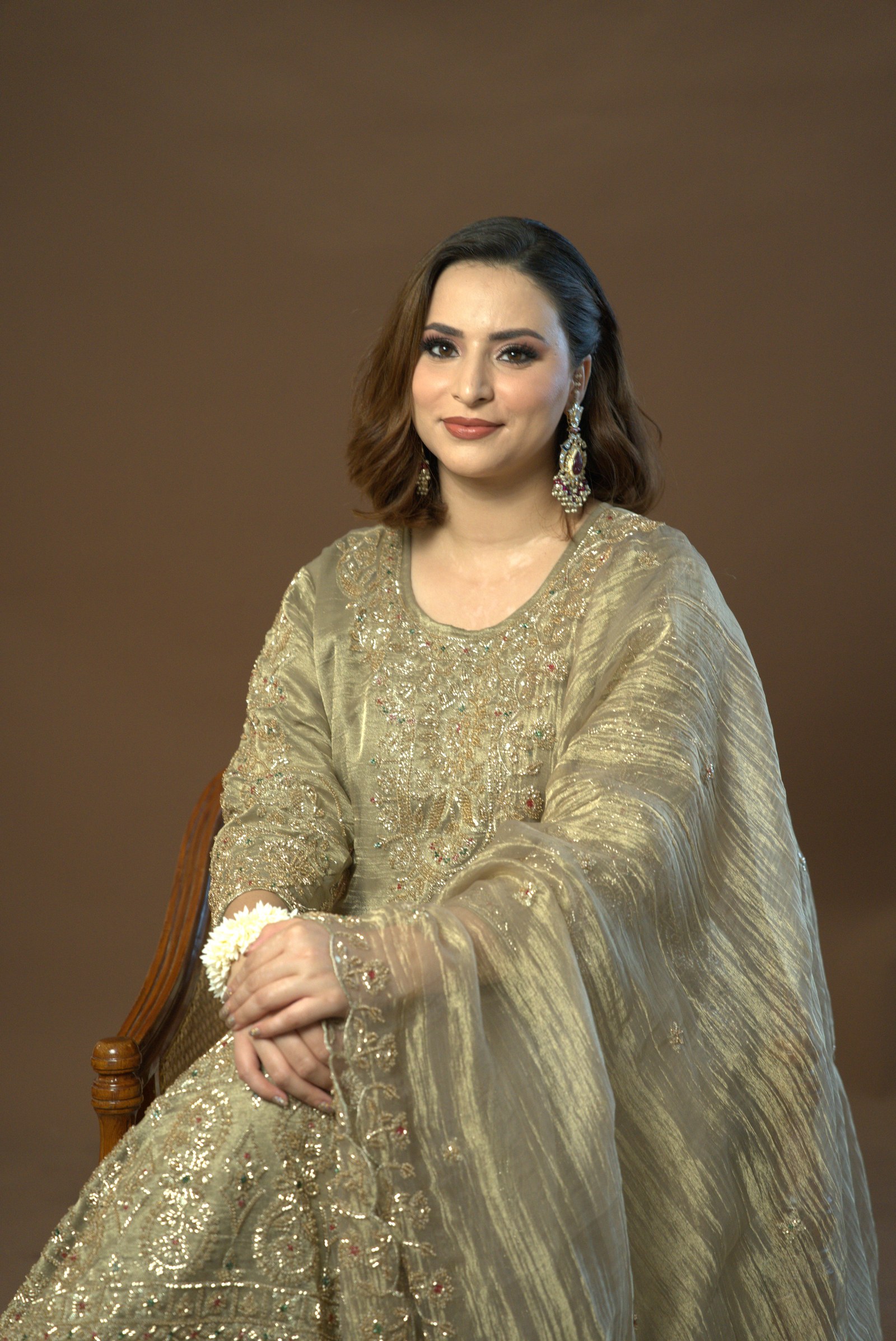 Close portrait showing the olive-gold suit and dupatta
